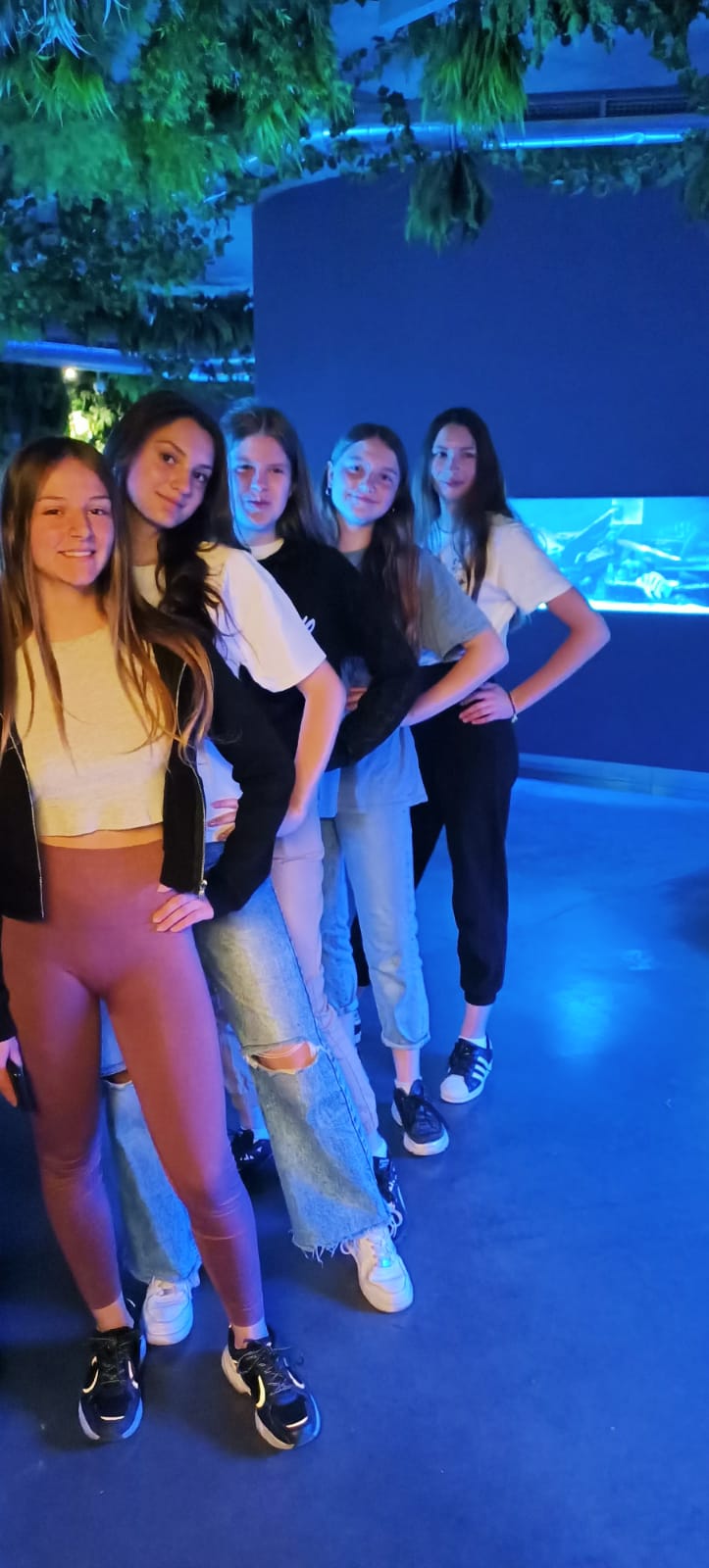 Pięć dziewcząt pozuje na tle akwarium