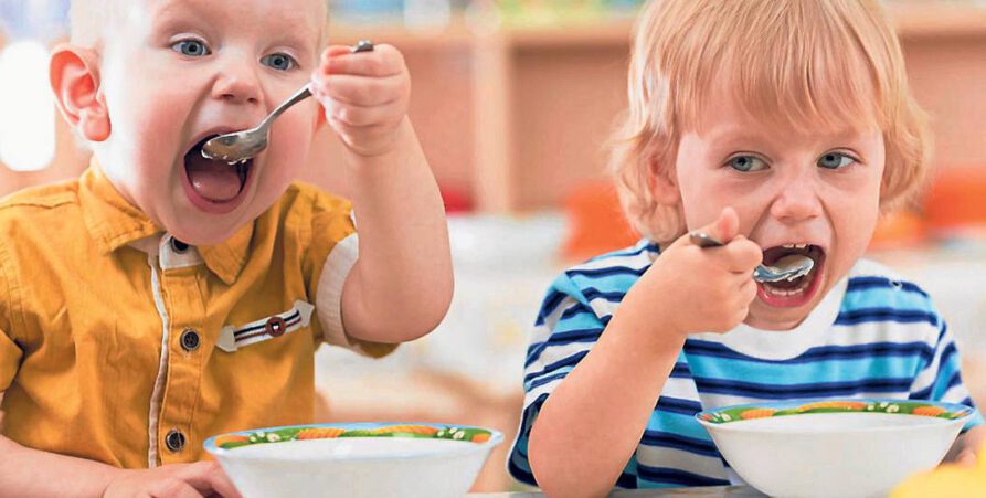 Dwójka małych dzieci z apetytem je posiłek