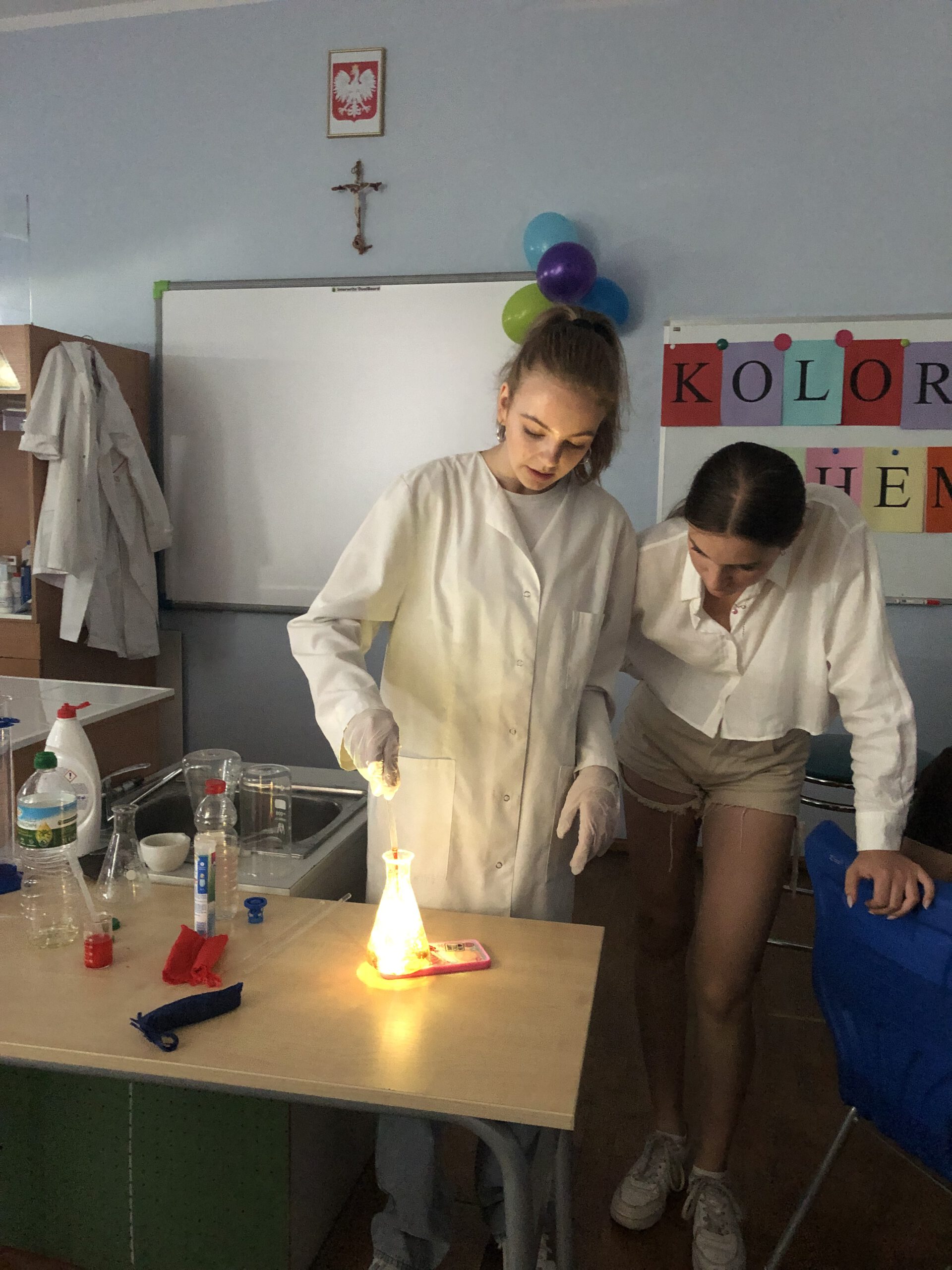 Dwie dziewczyny prowadzą doświadczenie chemiczne w kolbie