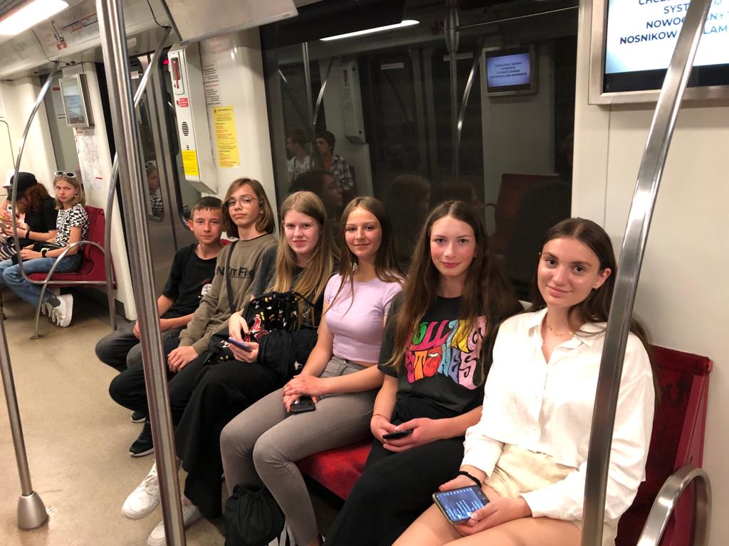 Cztery dziewczyny i dwóch chłopców siedzi w wagonie metra