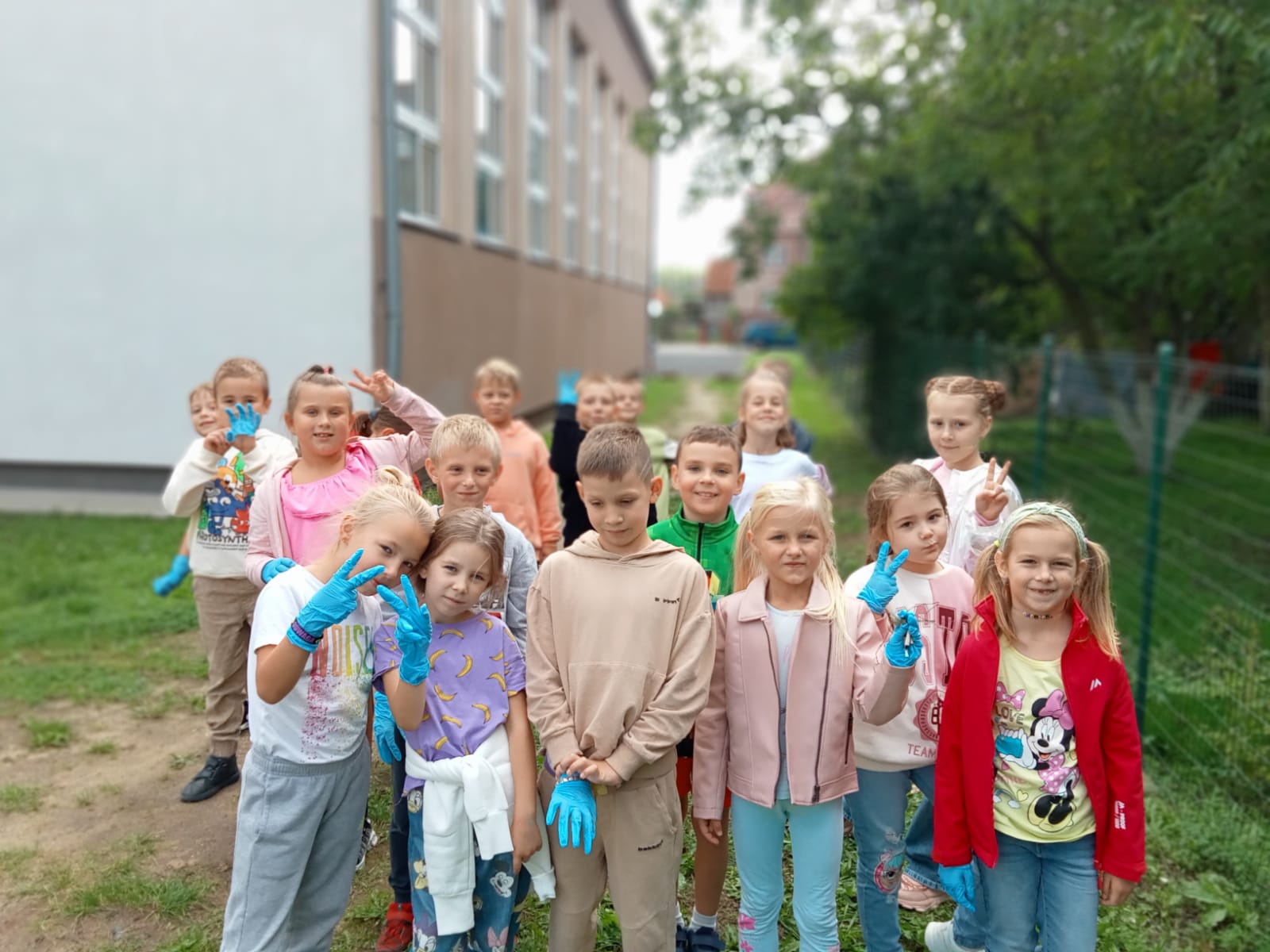Grupa dzieci sprzątających teren pozuje do zdjęcia