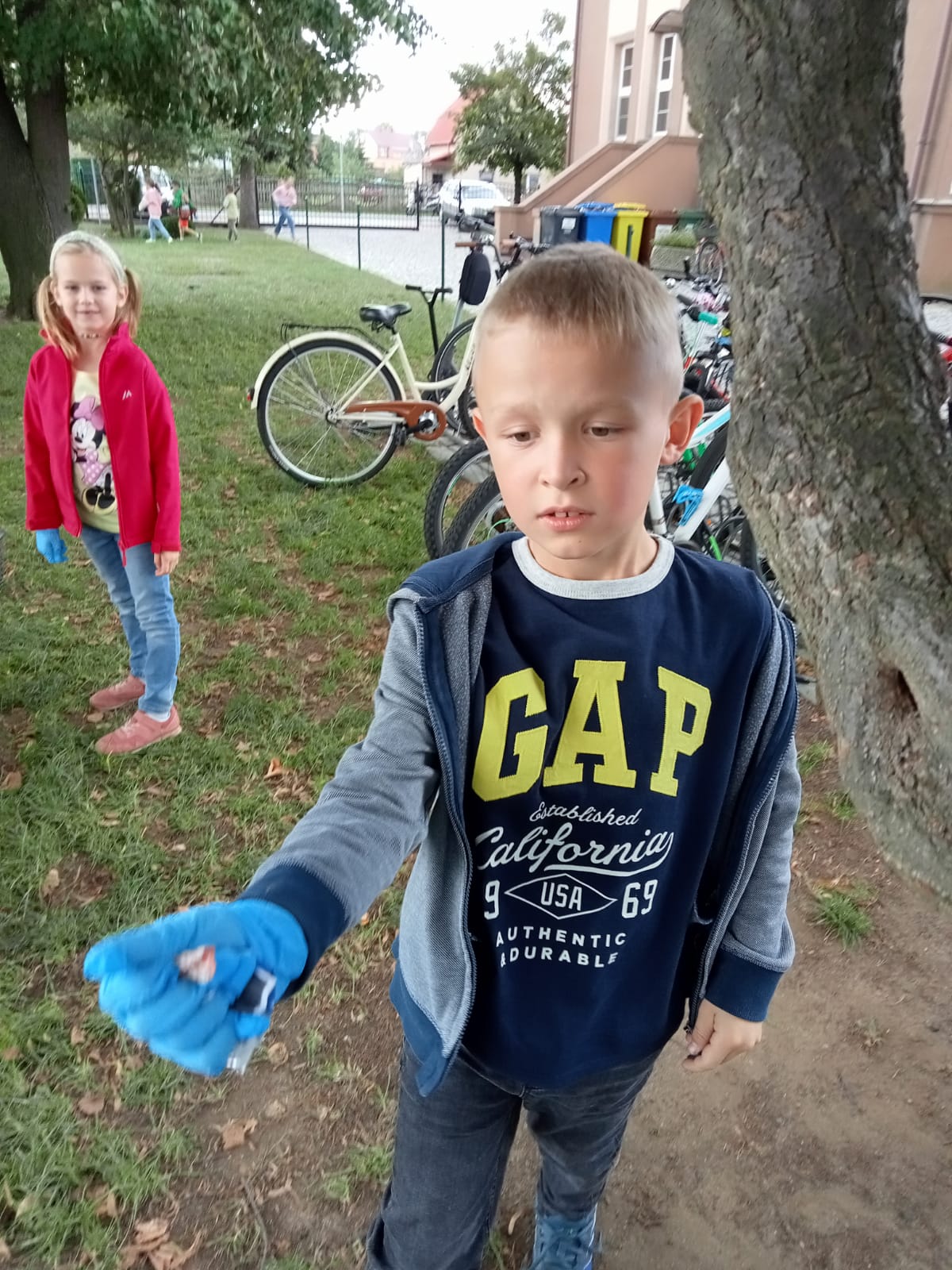 Chłopiec trzyma w ręku podniesione śmieci