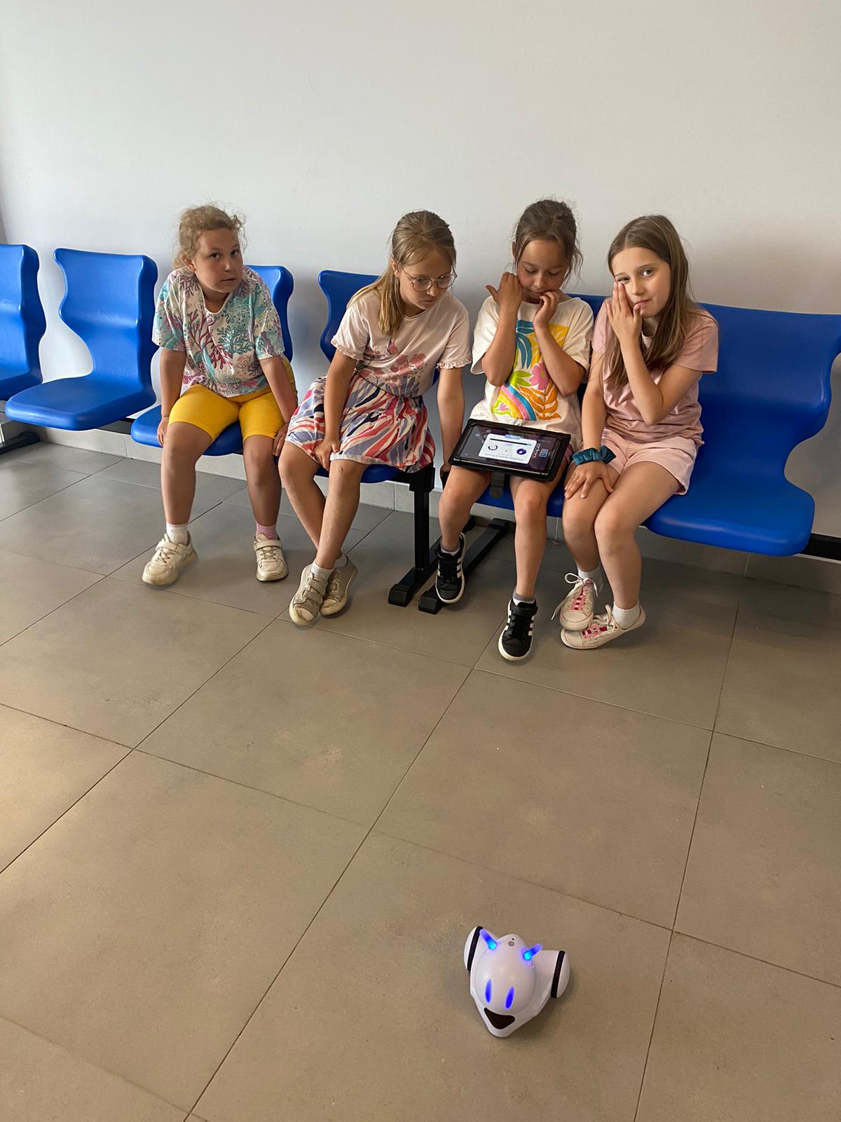Cztery dziewczynki sterują robotem za pomocą tabletu